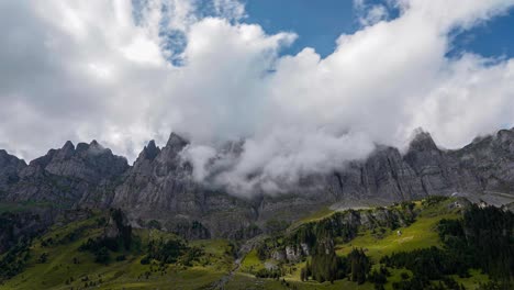 panoramic timelapse of grey mountains above grassy green hills in alps of urnerboden klausenpass switzerland