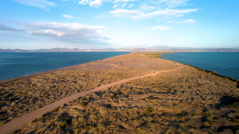 Drone-shot-of-the-dirt-road-that-leads-to-the-sandboarding-area-in-the-dunes-of-mogote-in-baja-california-sur-mexico