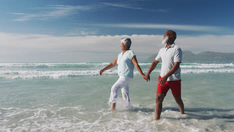 Älteres-Afroamerikanisches-Paar-Geht-Spazieren-Und-Hält-Händchen-Am-Strand