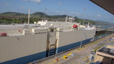 un enorme carguero que transporta autos cruzando una de las puertas del canal de panamá-1