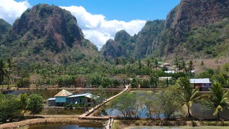 Aerial-of-beautiful-hidden-gem-Rammang-Rammang-Village-with-limestone-cliffs-and-huge-karst-mountains-in-Sulawesi,-Indonesia