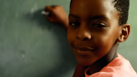 Portrait-of-schoolkid-writing-on-chalkboard-4k