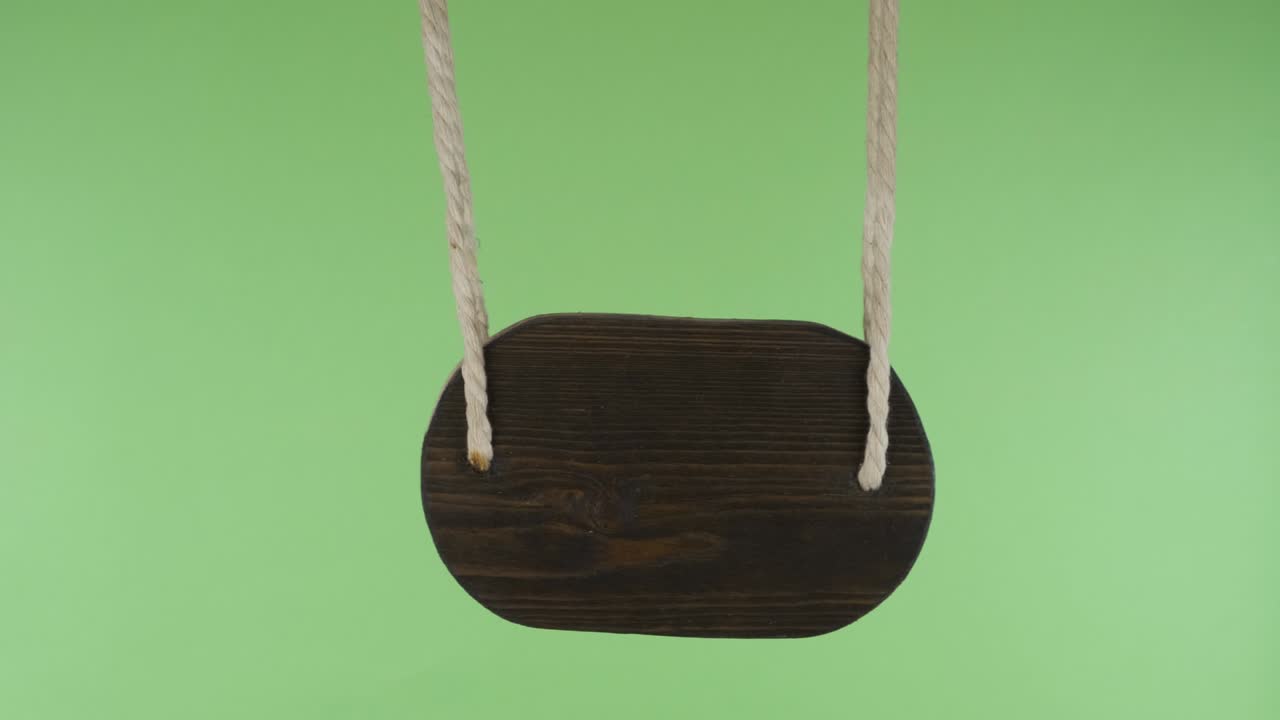 Puntatore in legno che oscilla al vento. Isolato su schermo verde.