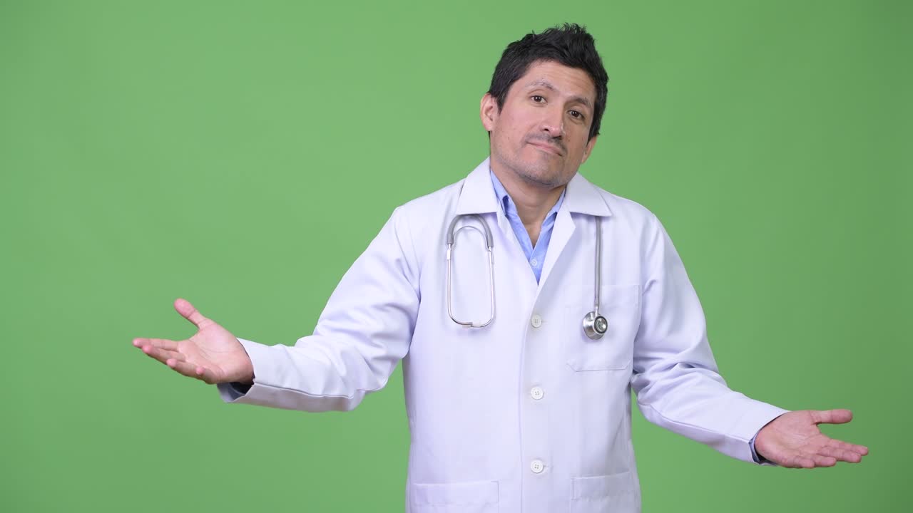 Serious Hispanic man doctor giving thumbs down