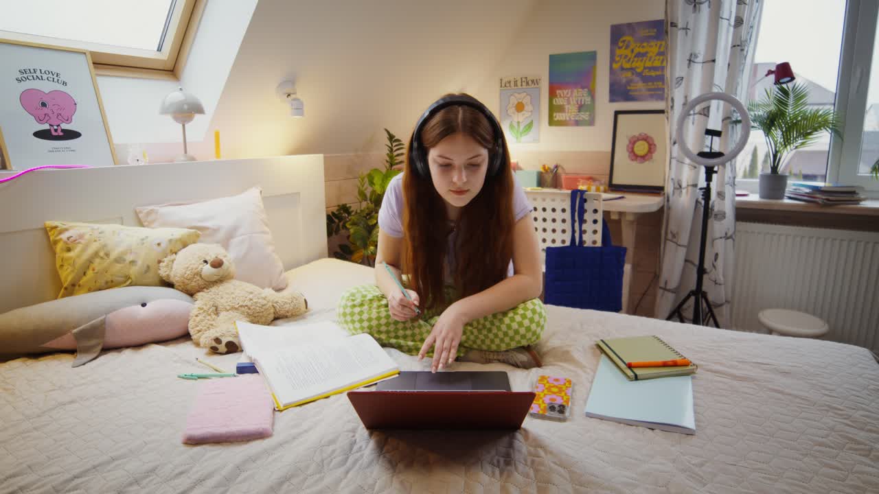 una adolescente estudiando en su dormitorio