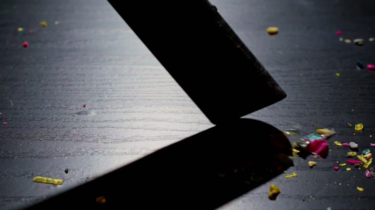 플라스틱 잔해는 화려한 조명 아래 테이블에서 진공청소되어 오염 청소와 환경 문제를 상징합니다.