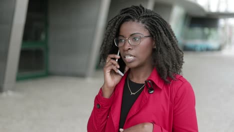 Mujer-Afroamericana-Hablando-Por-Teléfono-Afuera,-Luciendo-Seria