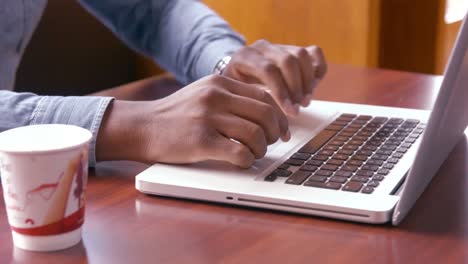 manos de hombre usando computadora portátil