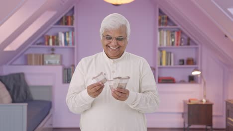 happy indian old man counting money