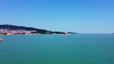 aerial panorama shot of the beautiful blue sea off the coast of weihai city, china at xingfu park with a view of the city buildings in asian architecture on a sunny summer day