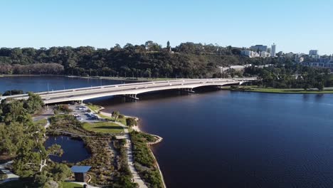 Vista-Aérea-De-Drones-Descendiendo-Sobre-El-Río-Swan-Y-El-Carril-Bici-De-La-Costa-Sur-De-Perth-Con-Kings-Park-Y-Puente-Estrecho-En-Perth