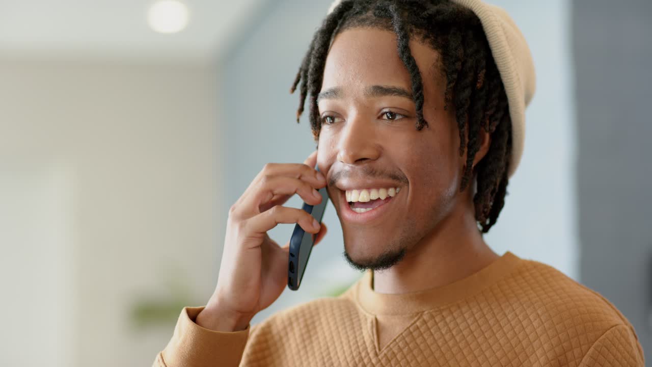 African American man reading smartphone message smiling recording reply and calling friend at home