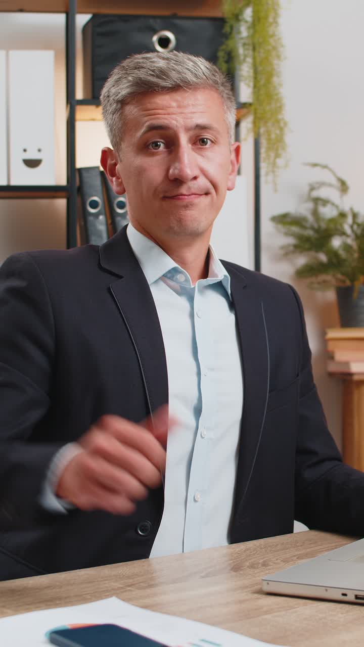 Upset young caucasian freelancer in suit using laptop and showing thumb down at home office table
