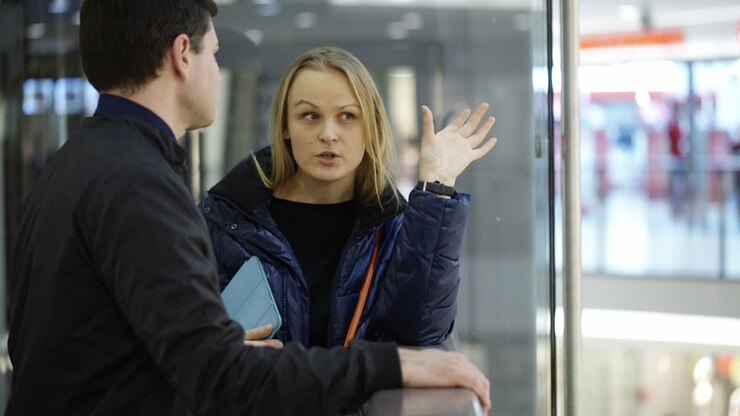 Uomo e donna che discutono in un centro commerciale