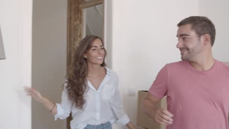 joven pareja caucásica entrando en un nuevo apartamento por primera vez