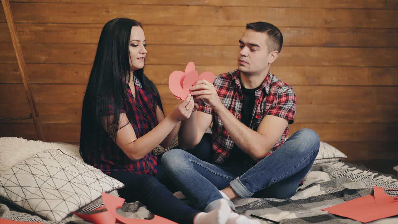 Young couple posing in studio. Portrait shot of the happy beautiful young man and woman looking at each other and then smiling to the camera
