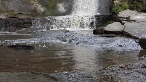 peaceful woodland forest splashing waterfall slow motion flowing paradise wilderness low rising angle