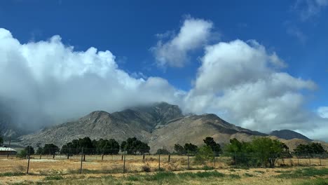 lapso de tiempo de 4k del paisaje montañoso rural con nubes que soplan girando alrededor de la montaña a través de cielos azules