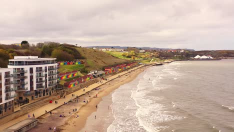 Scarborough-North-Bay-Beach-Colourful-Beach-Huts,-Aerial-Descend-Shot