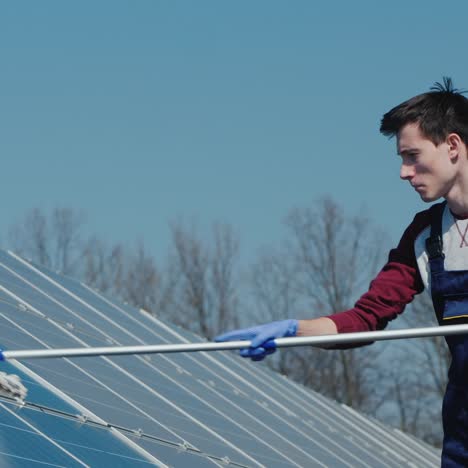 man washes solar panels at home power plant