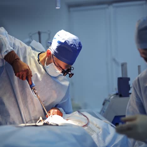 urgent neurosurgery operation provided by professional surgeons. medics in scrubs in neurosurgery room. selective light above operational table