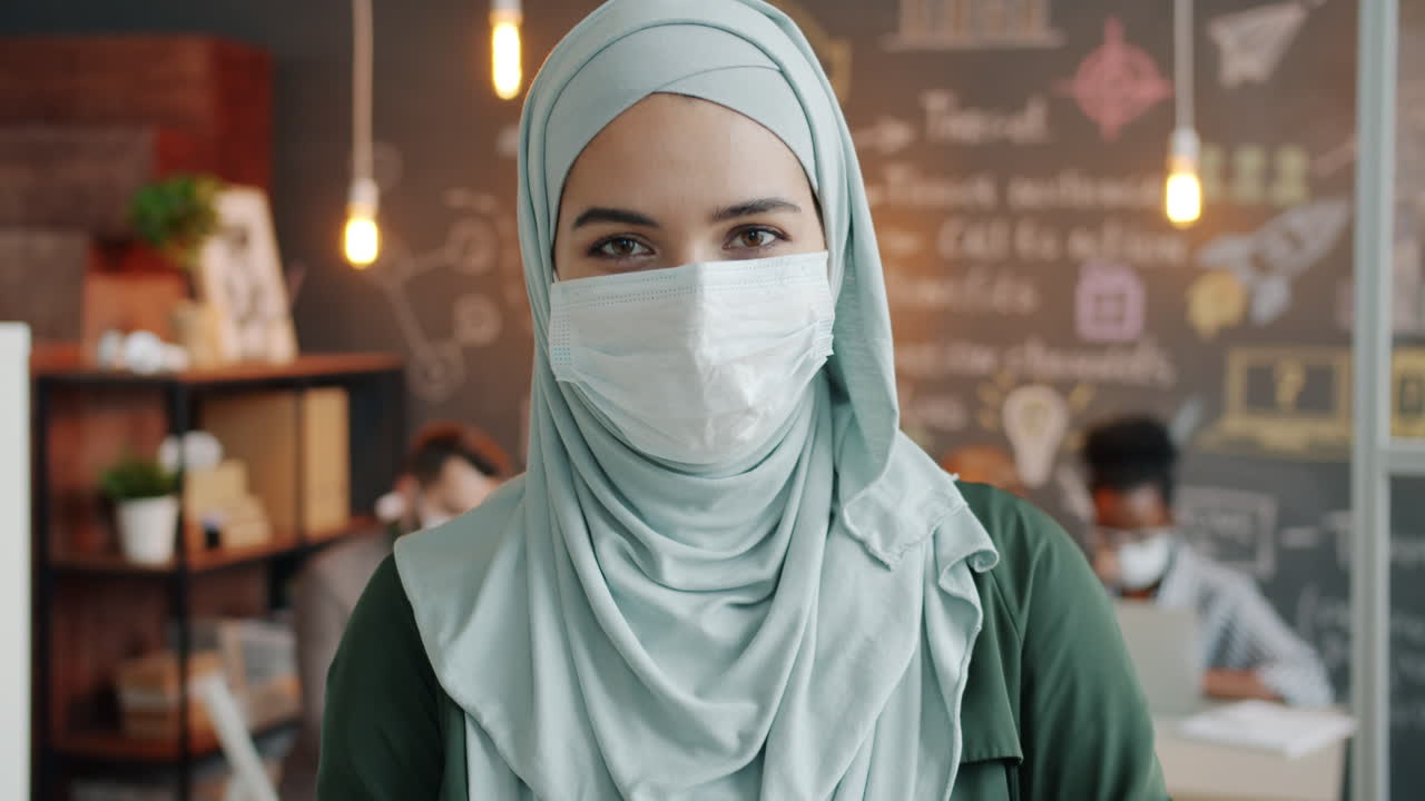 Woman in Hijab and Mask in Modern Office Setting