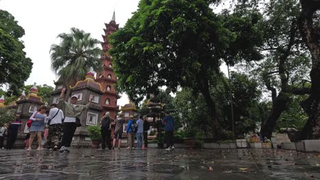 tourists exploring historic pagoda in wet weather