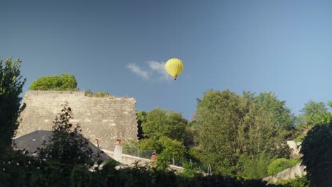 um dia de verão e um balão de ar flutuando sobre um antigo edifício de pedra.