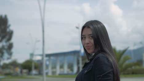 beautiful hispanic woman turning her head and smiling past the camera