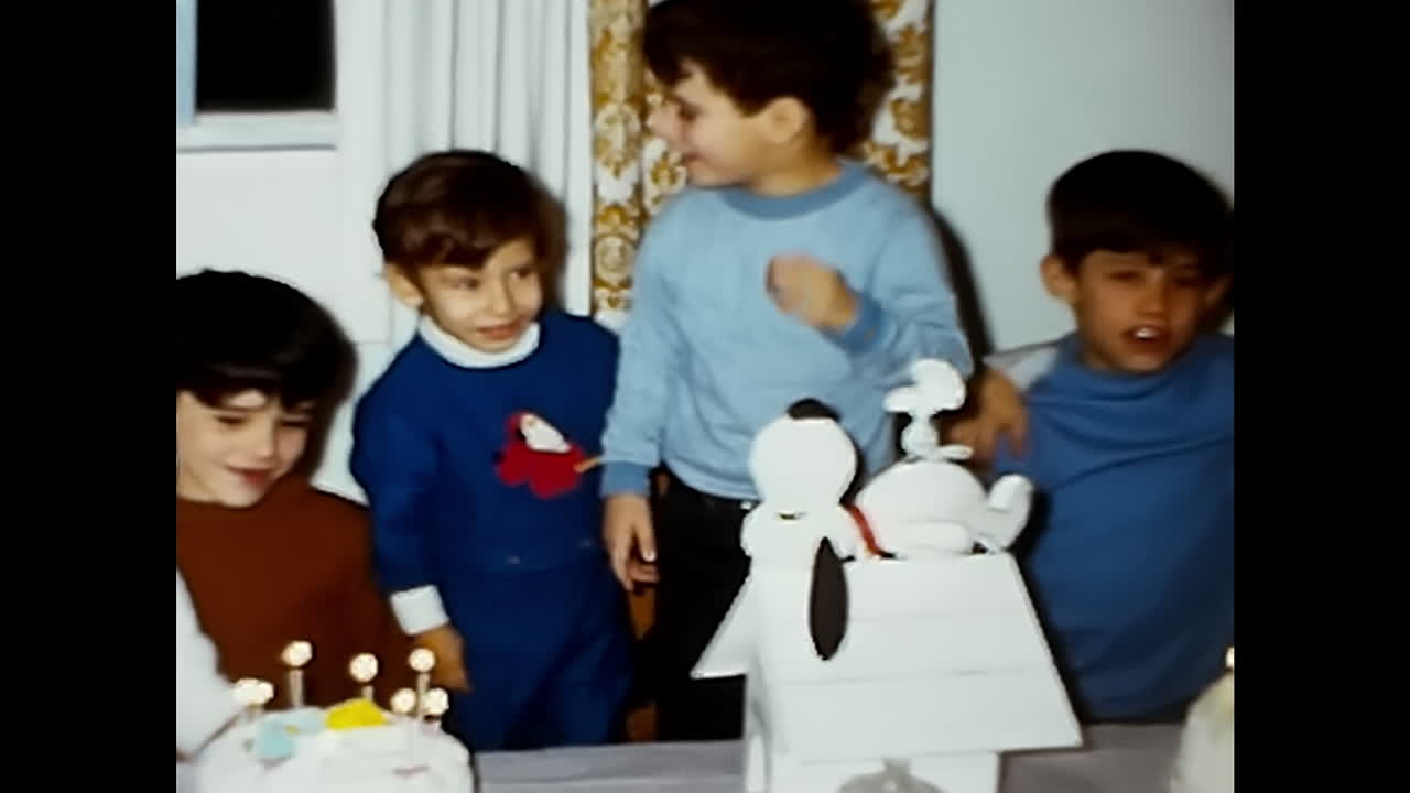 Young Boy Blowing Out Candles on a Cake. CIRCA USA - 1970s: A young boy with a birthday cake blowing out the candles during a celebration in the 1970s in the USA.