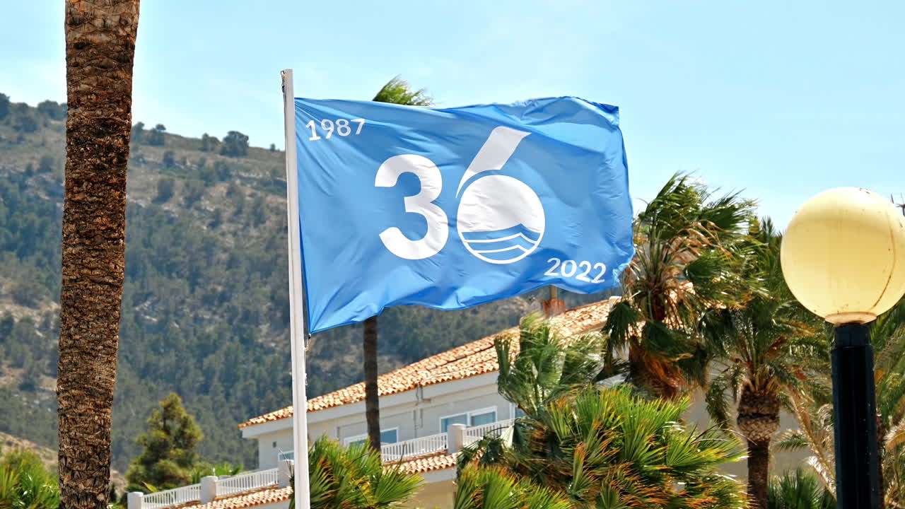 Bandiera blu sventolante ad Albir beach, provincia di Alicante, Spagna
