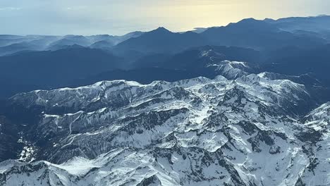 Aerial-side-view-from-a-jet-cockpit-flying-at-11000m-high-of-the-snowed-eastern-french-Alps-near-Nice-city,-with-the-Mediterranean-sea-at-the-back