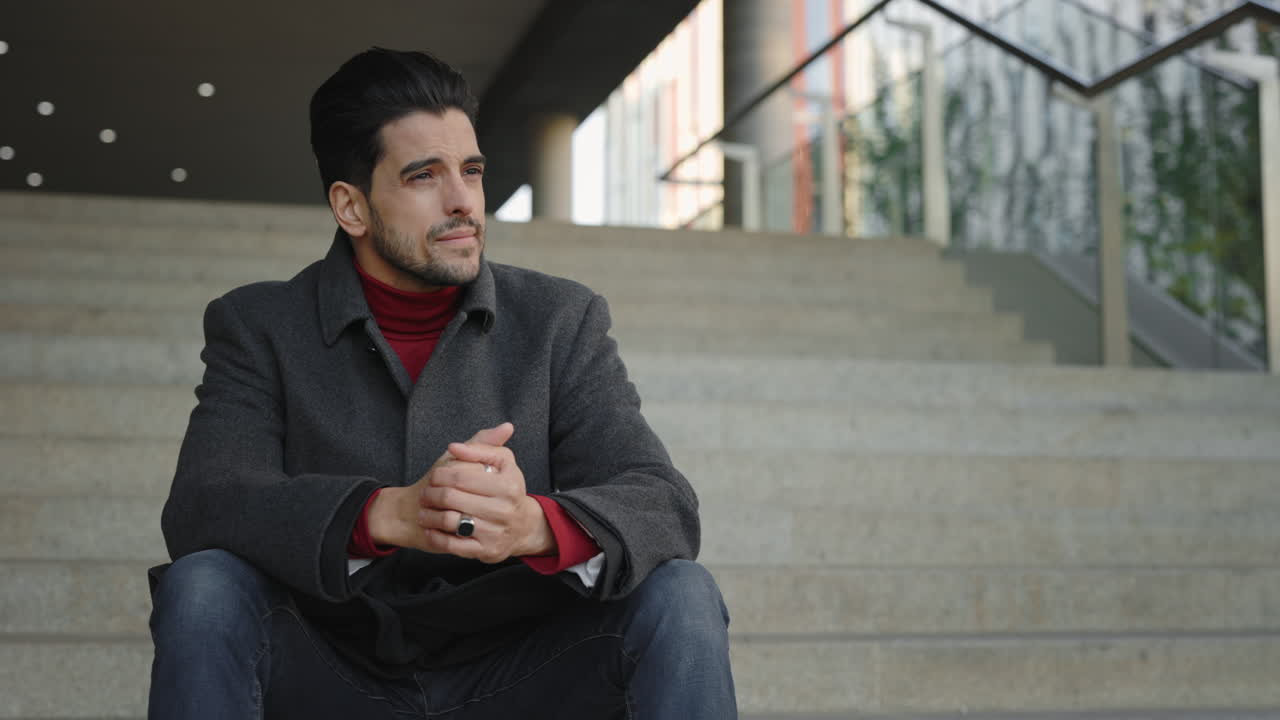 A man sitting on stairs in an urban setting