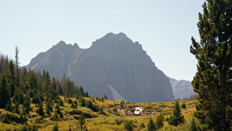 Stunning-nature-landscape-view-of-the-incredible-Red-Castle-Peak-up-a-backpacking-trail-in-the-High-Uinta-National-Forest-between-Utah-and-Wyoming-with-a-waterfall-and-pine-trees-in-the-foreground