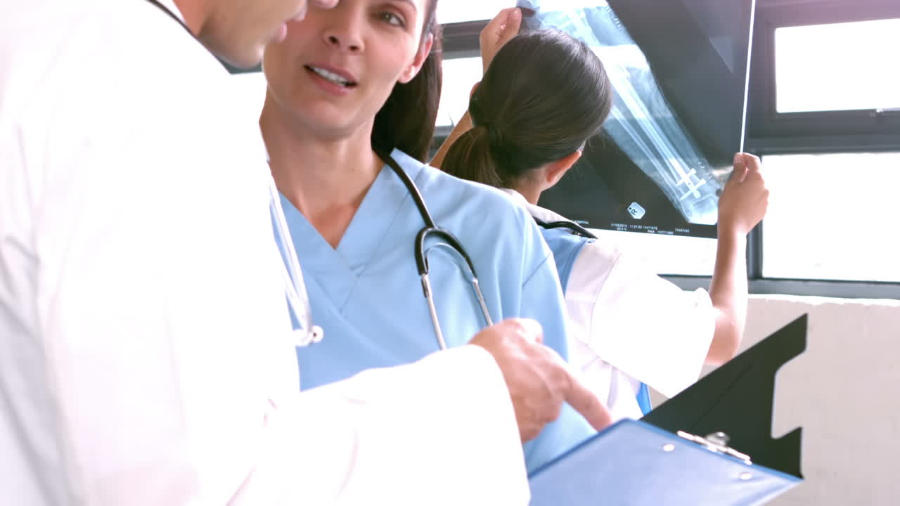 의사 들 이 클립보드 에서 보고서 에 대해 논의 하고 있다