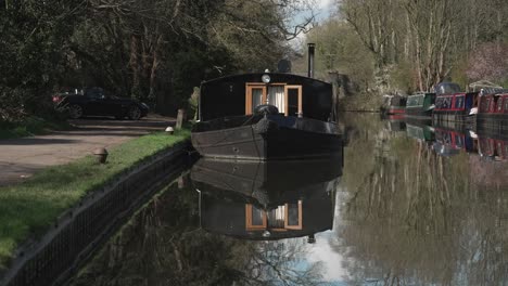 black widebeam boat moored on a canal