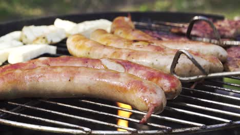 close up of german sausages called bratwurst on grill with flames