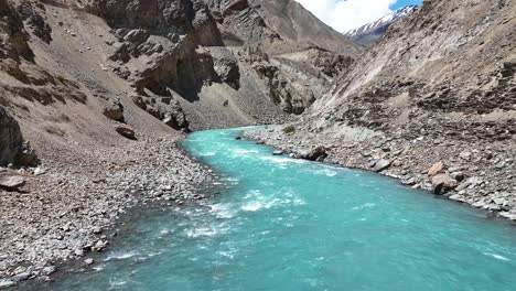 aerial drone shot of a peaceful mountain monastery situated beside a bright blue river.