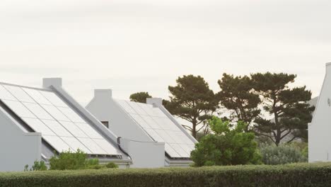 Houses-with-solar-panels-and-trees-in-garden-on-sunny-day