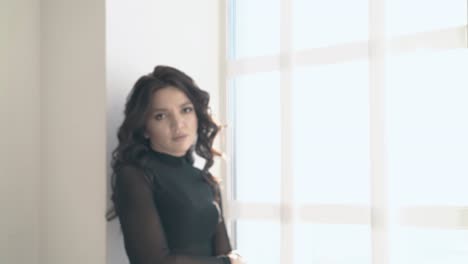 upset-pretty-girl-in-black-clothes-comes-to-window-in-loft