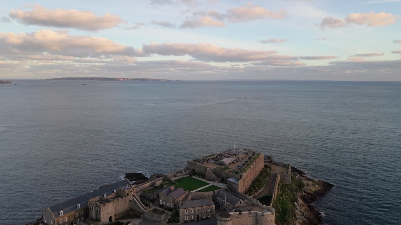 Filmato drone che rivela il Castello Cornet a St Peter Port, Guernsey, durante l'ora d'oro con mare calmo e nuvole rosate