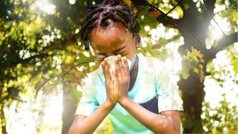 Afro-Junge,-Der-An-Einer-Allergie-Leidet-Und-Vor-Einem-Hellen-Baum-Im-Hintergrund-4k-Niest