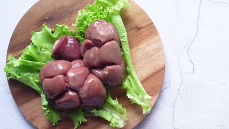 raw fresh lamb kidneys on a chopping board ,