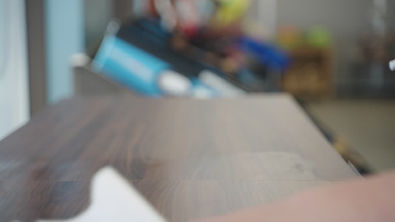 Unknown store empployee cleaning table surface and grocery market to ensure health safety by spraying sanitizer.