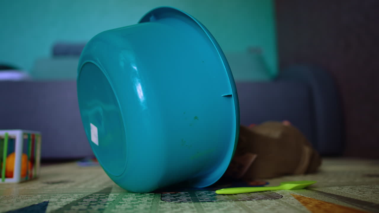 Cute smiling baby lying on the floor. Adorable child turns blue washtub hiding behind it.