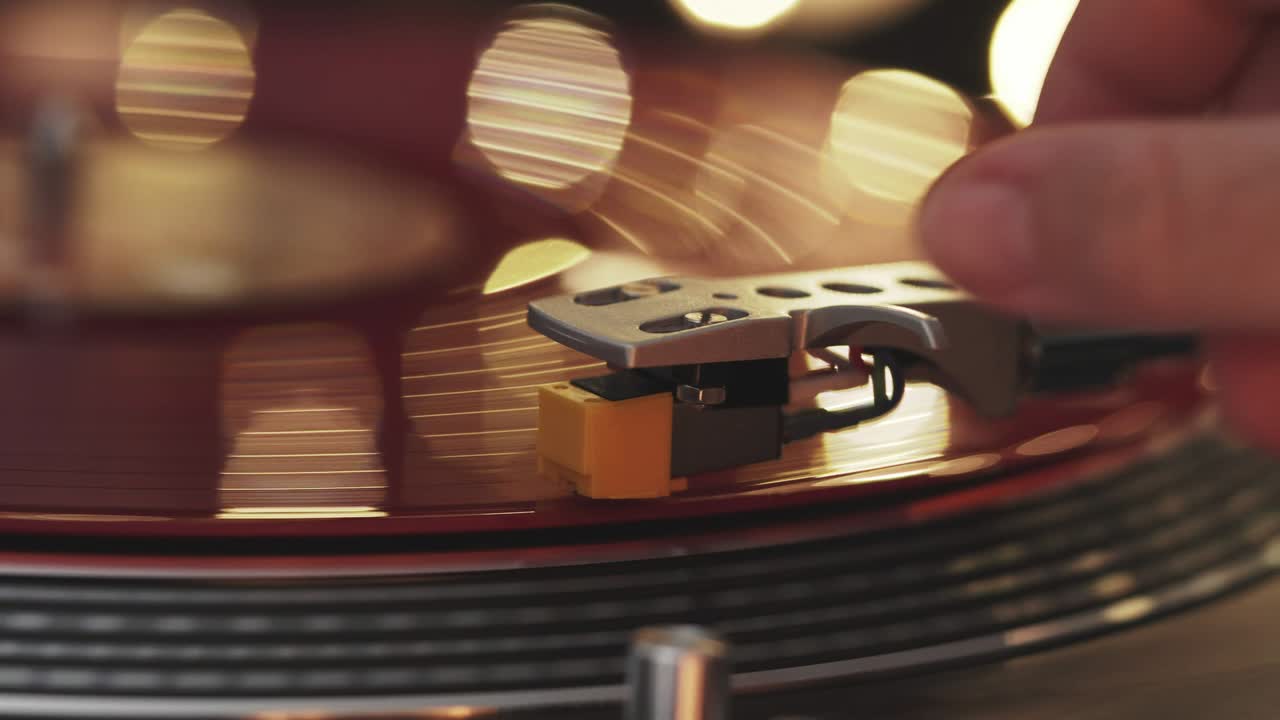 슬라이드 턴테이블 비닐 레코드 플레이어: 디제이 턴 테이블 음반 플레이어에서 비닐 레코드를 클로즈업, 스타일러스를 회전하는 빨간 비닐 판에 바늘로 부드럽게 넣고, 그라모폰과 토크 판을 포함합니다.
