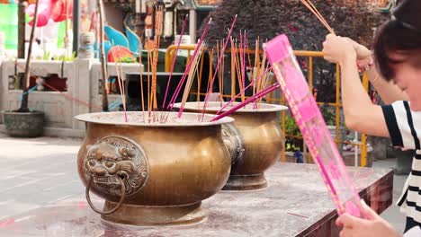 woman offering incense at hong kong temple