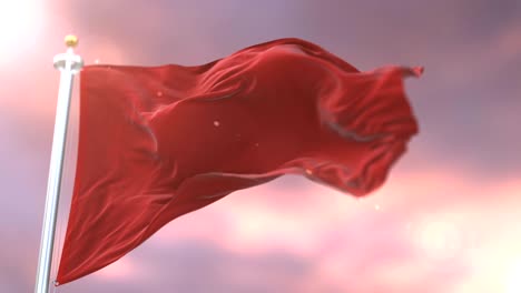 bandera roja agitando en el viento en lento al atardecer, bucle