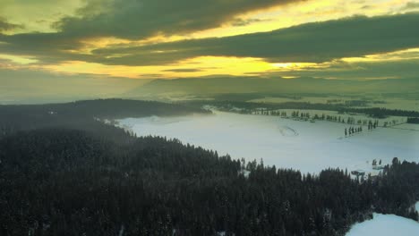 Winter-Wonderland:-Aerial-View-of-Snow-Covered-Farmland-in-Enderby,-BC-during-sunset