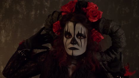 catrina cosplay girl moving her hands over her head slowly in a dark background, medium close up